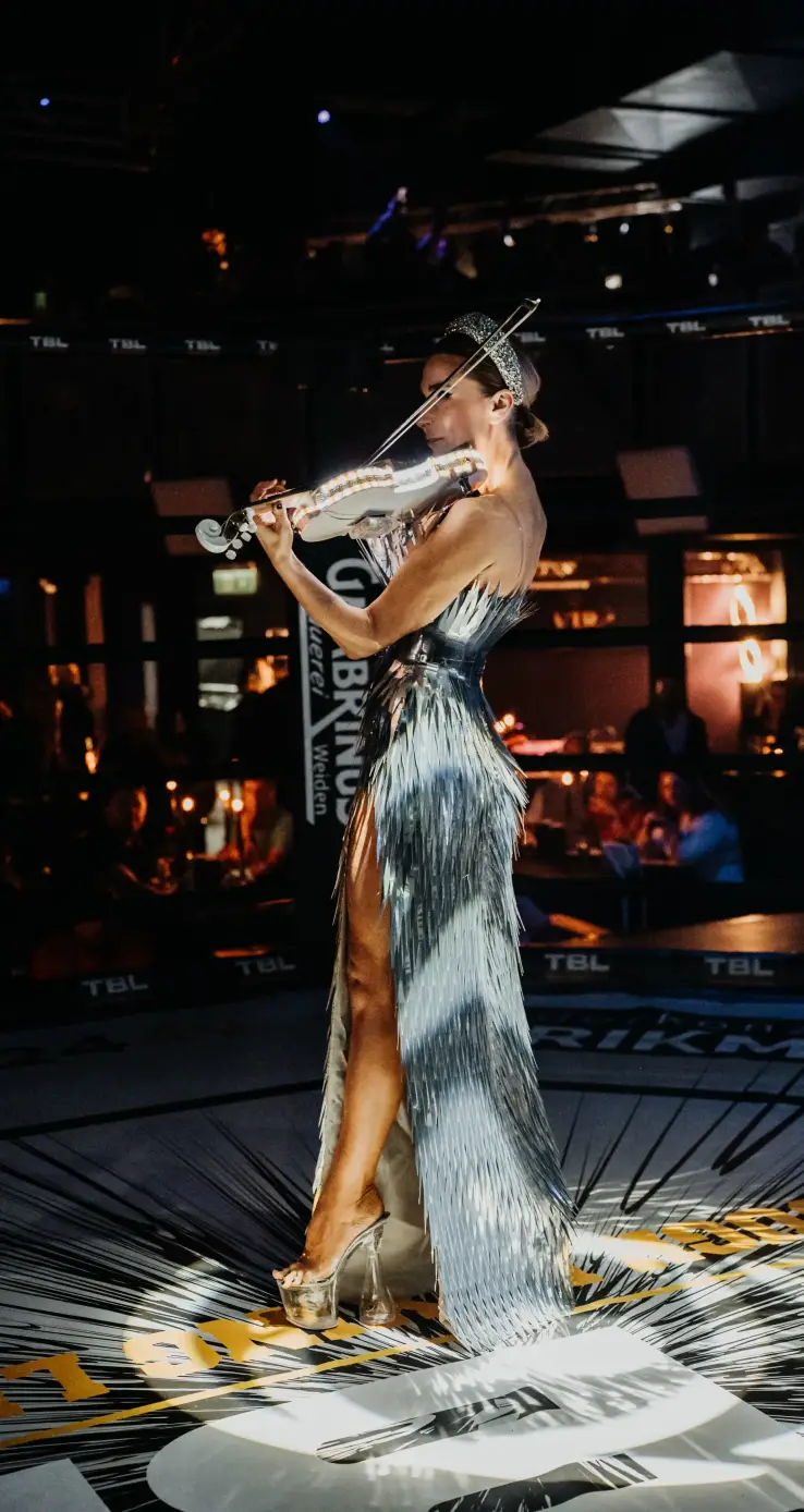 Female performer entertaining the crowd during a TBL Events MMA and combat sports event in a professional fight arena.